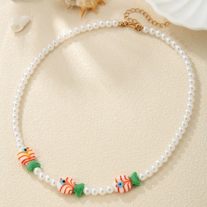 Detail of beaded pearl necklace featuring colorful tropical fish charms and gold clasp
