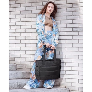 Large capacity black quilted travel tote bag for women, stylish puffer gym overnight bag.