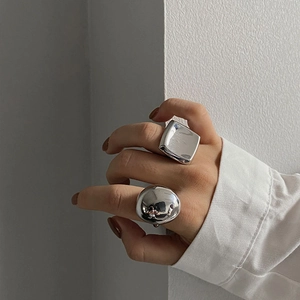 Close-up of minimalist silver geometric rings with polished finish on fingers