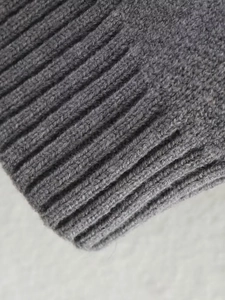 Detail shot of charcoal grey ribbed knit texture and cuff on bomber jacket fabric