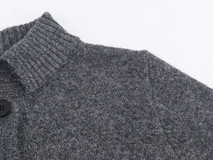Close-up of charcoal knit cardigan showing metallic silver threads and large black button