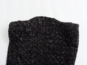 Close-up of high-density black sequins on round neck sleeveless mini dress fabric