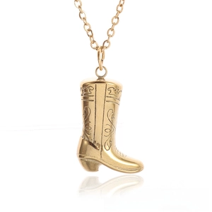 Detailed close-up of golden cowboy boot pendant with intricate Western style floral engraving