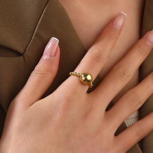 Close-up of minimalist gold-plated 18k beaded open ring on female finger
