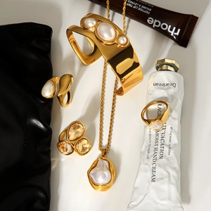 Golden jewelry set featuring baroque pearl necklace, bangle, and yellow zircon ring