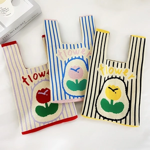 Close-up of thick knitted striped tote bags with cartoon tulip patterns and flower text