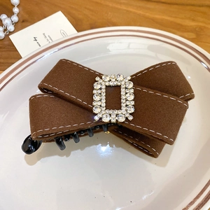 Detail view of coffee-colored suede bow hair clip with sparkling rectangle rhinestone