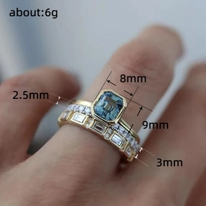 Luxury gold ring set with emerald cut blue center stone and pave diamond accents