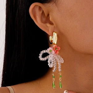 Detail of floral beaded tassel earrings with crystal drops worn by a model