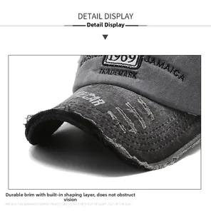 Detailaufnahme einer dunkelgrauen Baseballkappe im Used-Look mit Stickerei und Fransen