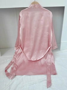 Detail of pink satin bathrobe with shawl collar and adjustable waist belt on a hanger