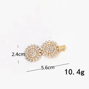 Detail view showing dimensions of a gold rhinestone hair clip with flower patterns