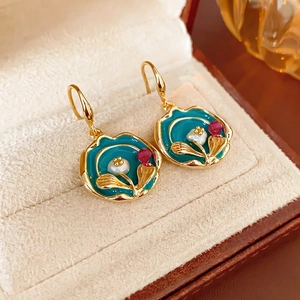 Vintage enamel floral drop earrings with pearls and blue gemstones in a jewelry box