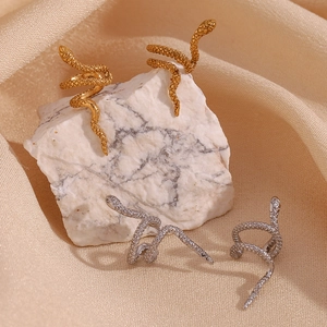 Detailed view of snake-scale texture ear cuffs in 18K gold and silver finishes