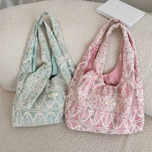 Flat lay detail of lace shoulder bags in green and pink with floral hollow patterns