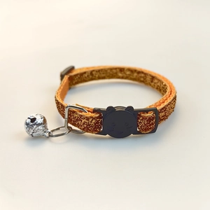 Detail of glitter cat collar with a silver bell and black cat-shaped safety buckle