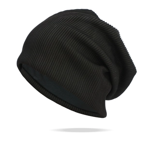 Détail de la texture en maille côtelée noire d'un bonnet souple pour femme au style pur