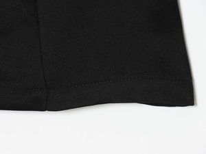 Gros plan détaillé de l'ourlet à double couture et de la qualité du tissu de la robe noire