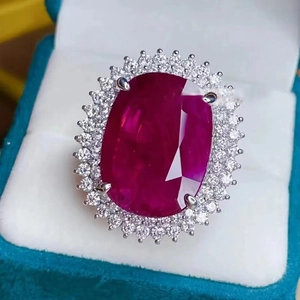 Elegant Diana-style silver ring with large oval ruby and diamond halo in a blue box