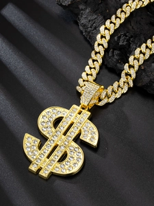 Macro shot of gold Cuban chain necklace with iced-out dollar sign pendant on black rock
