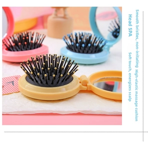 Detail view of foldable hair brushes with mirror in pink, blue and yellow macaron colors