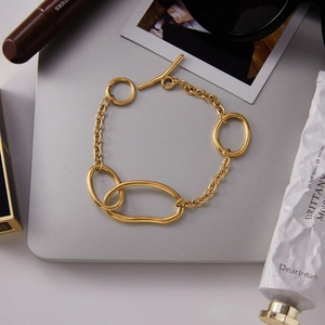 Detail view of gold stainless steel bracelet with irregular links and OT toggle clasp