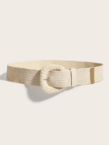 Détail de la ceinture tressée beige avec une grande boucle ronde et une texture en raphia