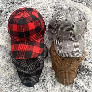 Flat lay of four checkered plaid baseball caps in various colors on a soft fur background