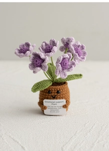 Macro shot of a hand-knitted emotional support plant with purple flowers and a message card