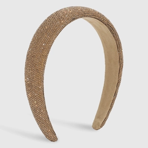 Detailed view of champagne gold padded headband with densely set sparkling rhinestones