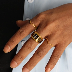 Three-piece ring set with vintage black cross and minimalist gold wavy stacking bands
