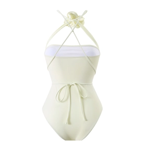 Detail of cream one-piece swimsuit with halter neck and 3D floral accent on white background