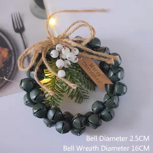 Détail d'une couronne de cloches de Noël de 16cm avec aiguilles de pin et baies