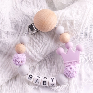 Detail of beech wood pacifier clip with lavender silicone beads and crown decoration