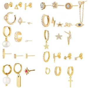 Macro shot of 10 gold-plated earring sets with pearls, crystals and red enamel motifs
