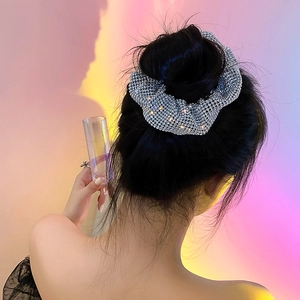 Detailed view of shiny crystal rhinestones on a silver oversized hair scrunchie