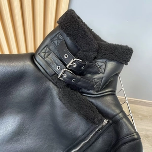Detail von Kunstfellkragen und Metallschnallen an schwarzer Biker-Lederjacke
