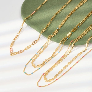 Detailed close-up of golden stainless steel necklaces with colorful enamel and beads accents