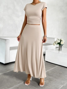 Detail eines beigen Kurzarm-Top und High Waist A-Linien-Maxirock-Sets an einem Model