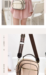 Detailed view of cream leather crossbody bag with multiple zippers and patterned strap