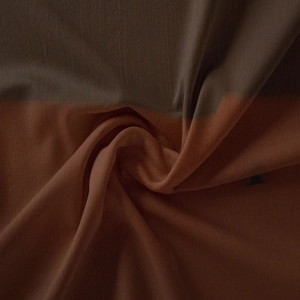 Macro shot of bohemian tapestry fabric with a rich brown gradient and fine texture