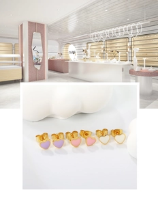 Detailed set of three heart earrings in purple, pink, and beige with golden finishes