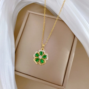 Luxurious gold necklace featuring a green flower pendant with sparkling crystals on box