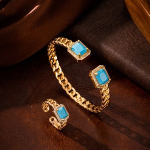 Close-up of gold bridal jewelry set with blue gemstones on brown leather texture