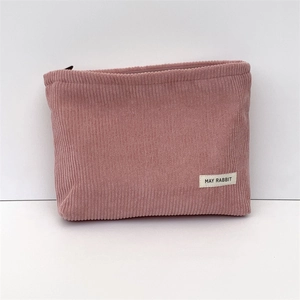 Detail shot of the pink corduroy makeup bag with a minimalist May Rabbit woven label