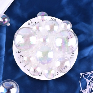 Close-up of colorful iridescent bubble cake toppers in various sizes on a decorative plate