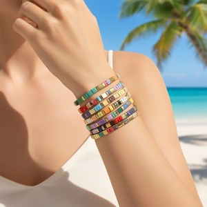 Close-up of colorful Tila bead stretch bracelets worn in a tropical beach setting