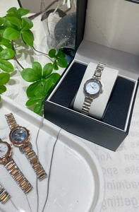 Three variants of women's quartz watches with petal bezels and metal link bracelets in gift boxes