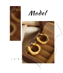 Detailed close-up of chunky gold-plated U-shaped earrings on a premium velvet jewelry box