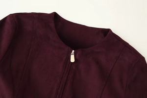 Detail of burgundy faux suede jacket neckline showing collar stitching and metal zipper
